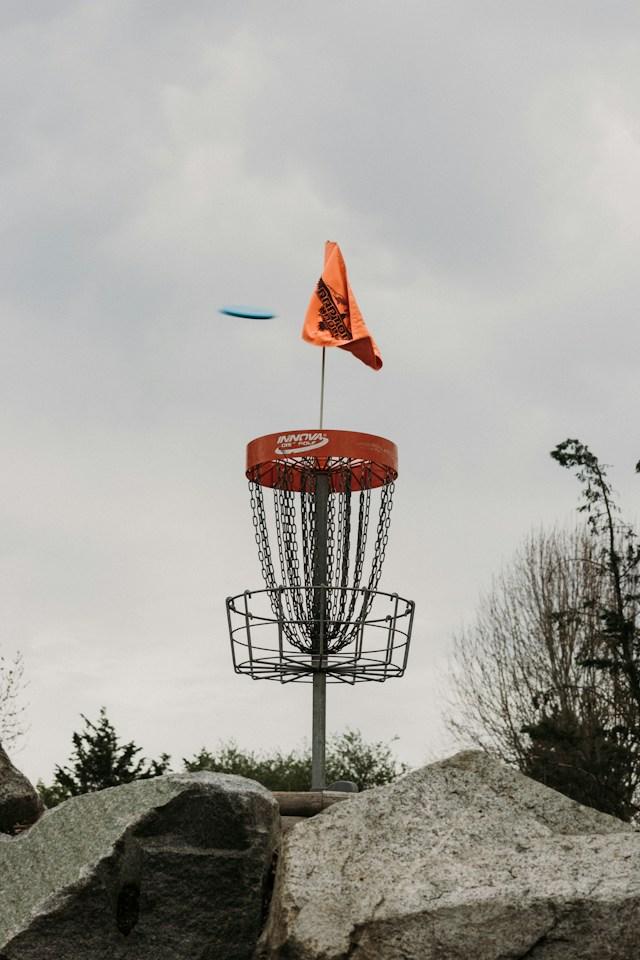 Blå disc i luften over en kurv med oransje flagg